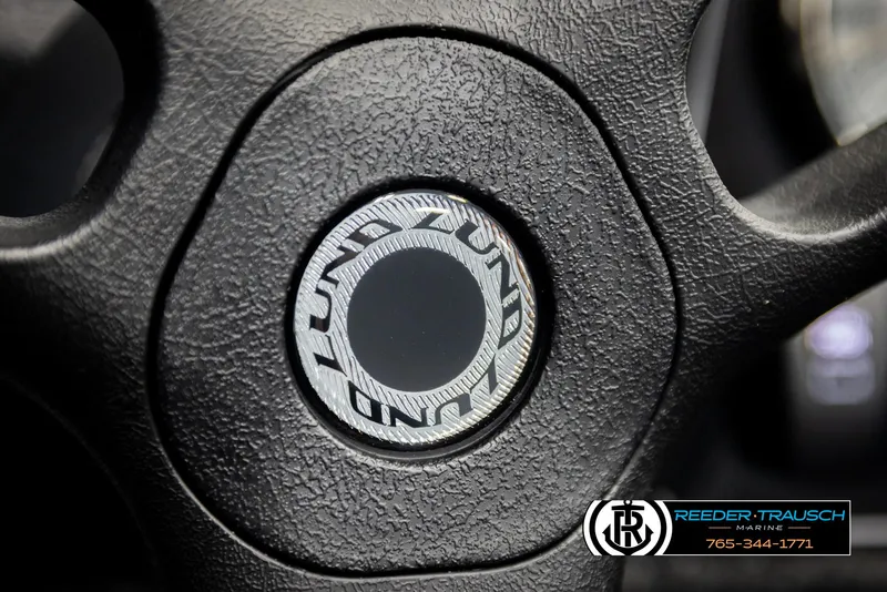 Slide: The Image of Steering wheel of 2026 Lund 1650 Rebel XL SS boat, featuring textured grip and logo. - 26