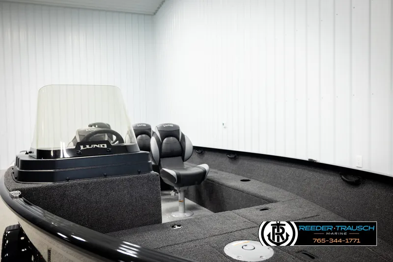 Slide: The Image of 2026 Lund 1650 Rebel XL SS boat interior with seating and steering console in showroom. - 35