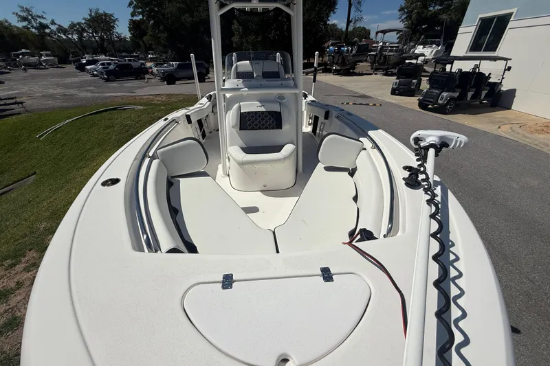 Slide: The Image of 2023 Tidewater 210 LXF boat with spacious seating and modern design in a marina setting. - 16