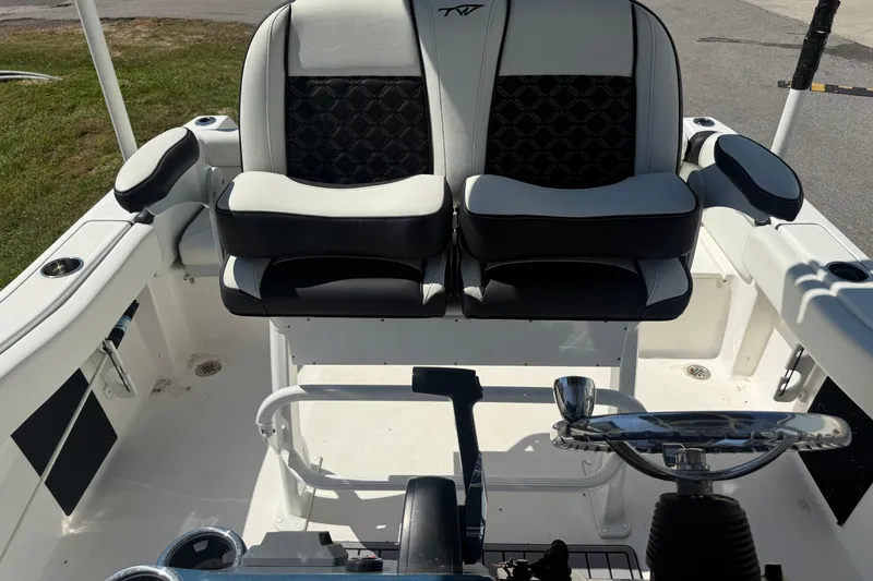 Slide: The Image of 2023 Tidewater 210 LXF boat interior with dual seats and steering wheel. - 20