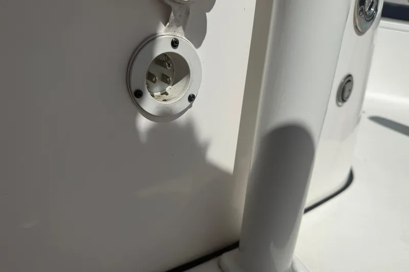Slide: The Image of Close-up of a 2023 Tidewater 210 LXF boat's electrical outlet on a white surface. - 24