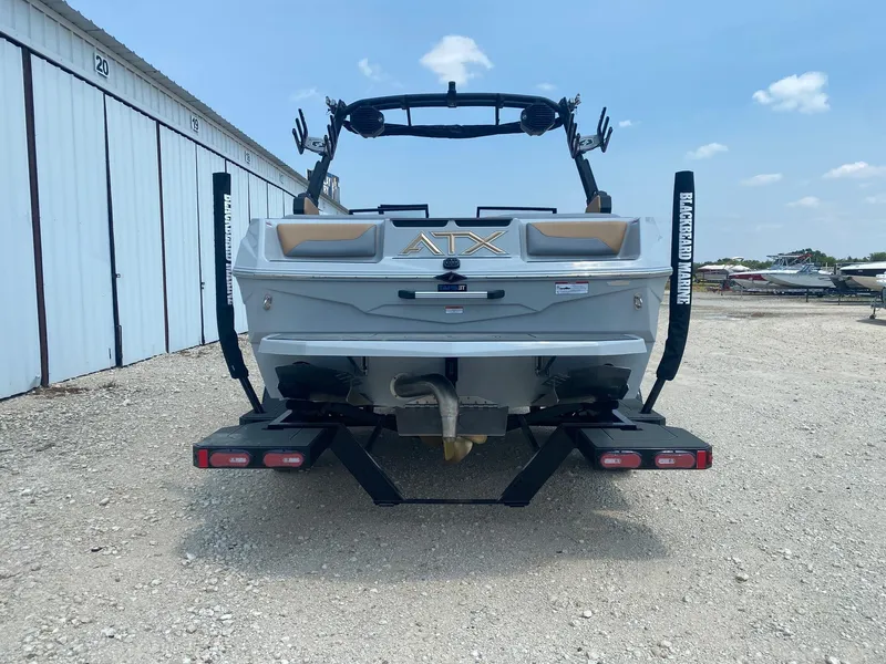 Slide: The Image of 2026 ATX Surf Boats 20 Type-S, rear view, parked outdoors near storage units. - 4