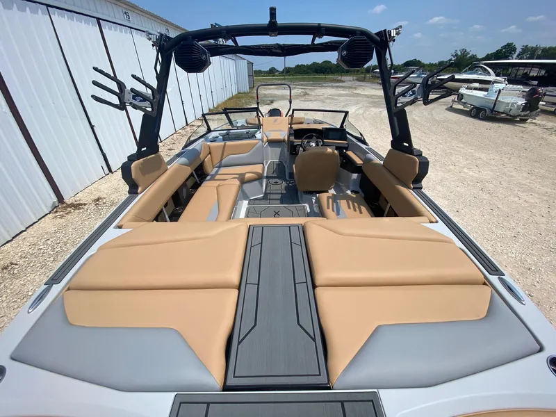 Slide: The Image of 2026 ATX Surf Boats 20 Type-S interior with tan and gray seating, docked outdoors. - 6