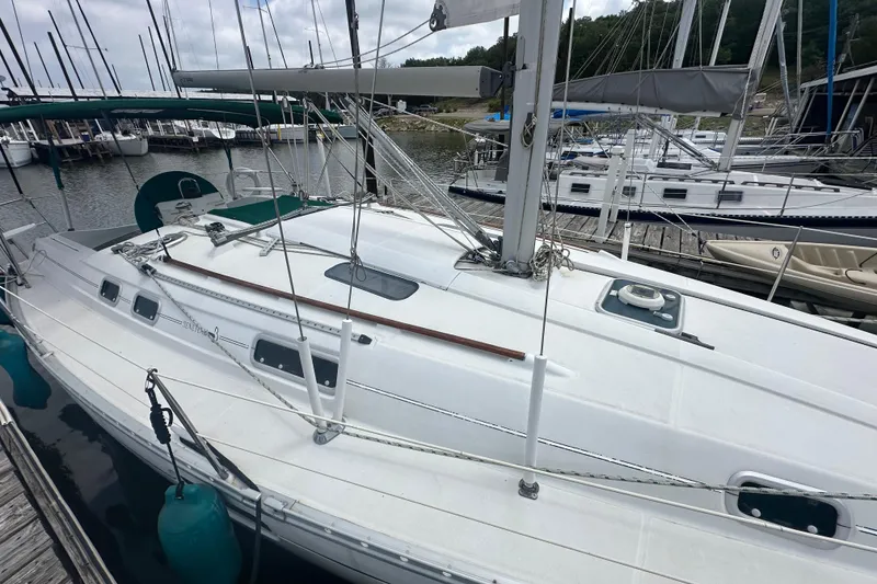 Slide: The Image of 1998 Beneteau Oceanis 352 sailboat docked at marina, featuring sleek white deck design. - 10