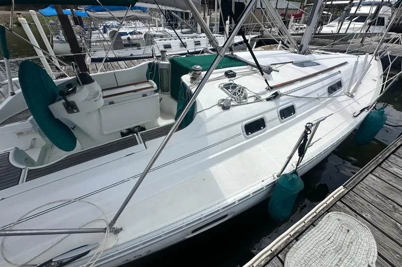 Slide: The Image of 1998 Beneteau Oceanis 352 sailboat docked, featuring a sleek white design and green accents. - 12