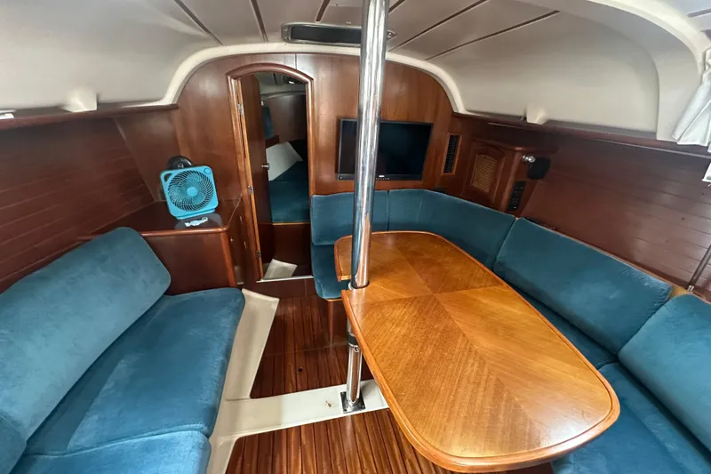 Slide: The Image of Interior of 1998 Beneteau Oceanis 352 sailboat with wooden table and blue seating. - 15