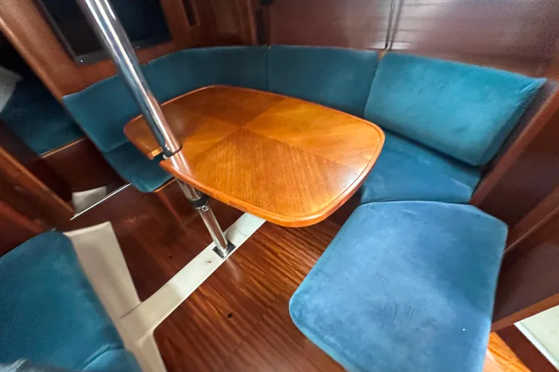 Slide: The Image of Interior of 1998 Beneteau Oceanis 352 sailboat with wooden table and blue seating. - 18