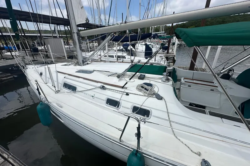 Slide: The Image of 1998 Beneteau Oceanis 352 sailboat docked at marina, featuring green canopy and white deck. - 8