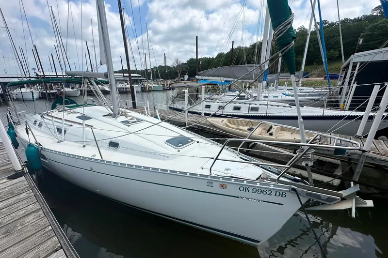 Slide: The Image of 1998 Beneteau Oceanis 352 sailboat docked at a marina under a cloudy sky. - 9