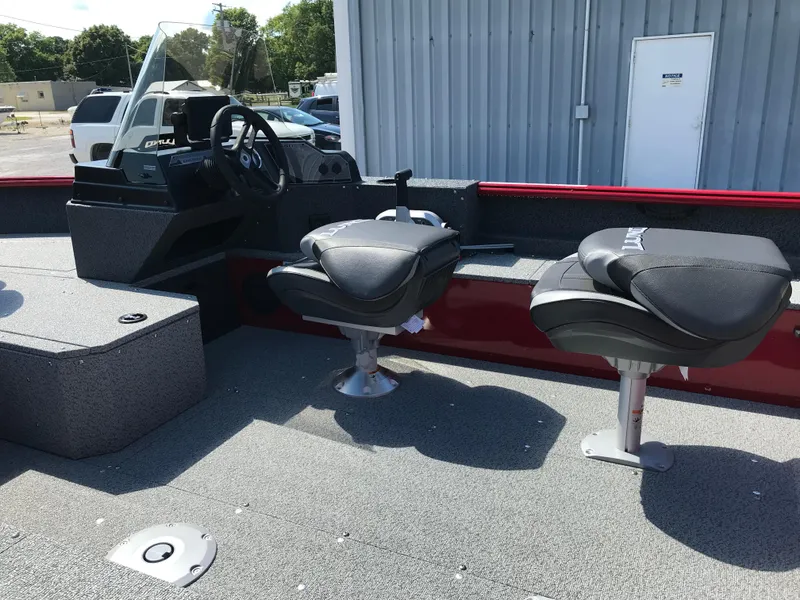 Slide: The Image of 2026 Lund 1800 Explorer SS boat on trailer, parked near industrial buildings. - 14