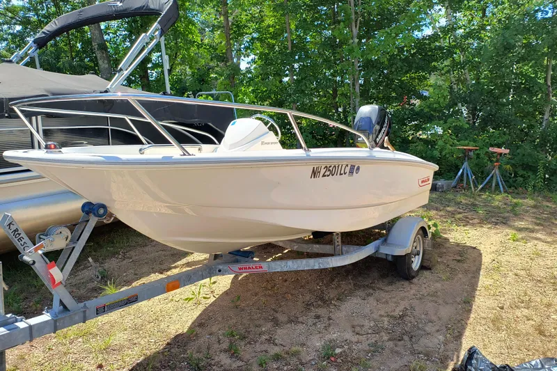 Slide: The Image of 2016 Boston Whaler 130 Super Sport boat on trailer, parked outdoors. - 0