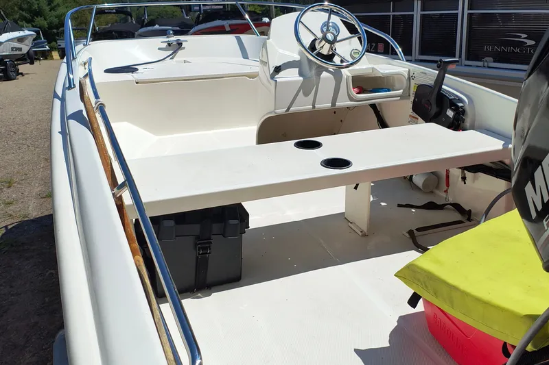 Slide: The Image of 2016 Boston Whaler 130 Super Sport interior with steering wheel and seating area. - 3