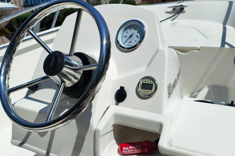 Slide: The Image of 2016 Boston Whaler 130 Super Sport dashboard with steering wheel and gauges. - 5