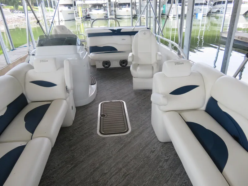 Slide: The Image of 2021 JC SportToon 24 TT CS pontoon boat interior with white seating and wood flooring. - 4
