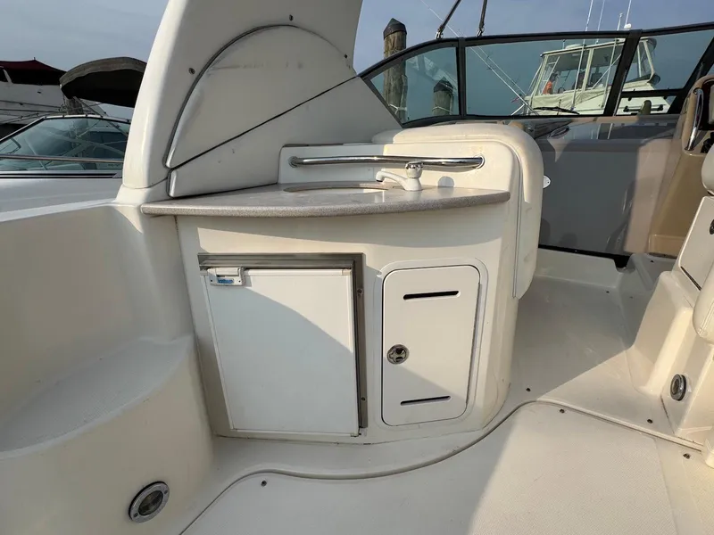 Slide: The Image of 2003 Sea Ray 320 Sundancer cockpit with sink and storage compartments. - 10