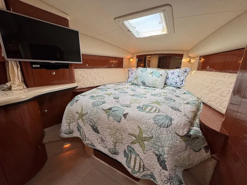Slide: The Image of Luxurious cabin interior of 2003 Sea Ray 320 Sundancer with cozy bedding and TV. - 16