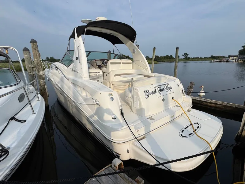 Slide: The Image of 2003 Sea Ray 320 Sundancer docked, featuring sleek design and spacious deck. - 2