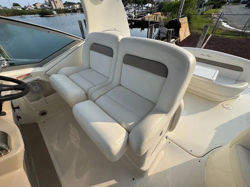 Slide: The Image of 2003 Sea Ray 320 Sundancer boat interior with white seating and waterfront view. - 5