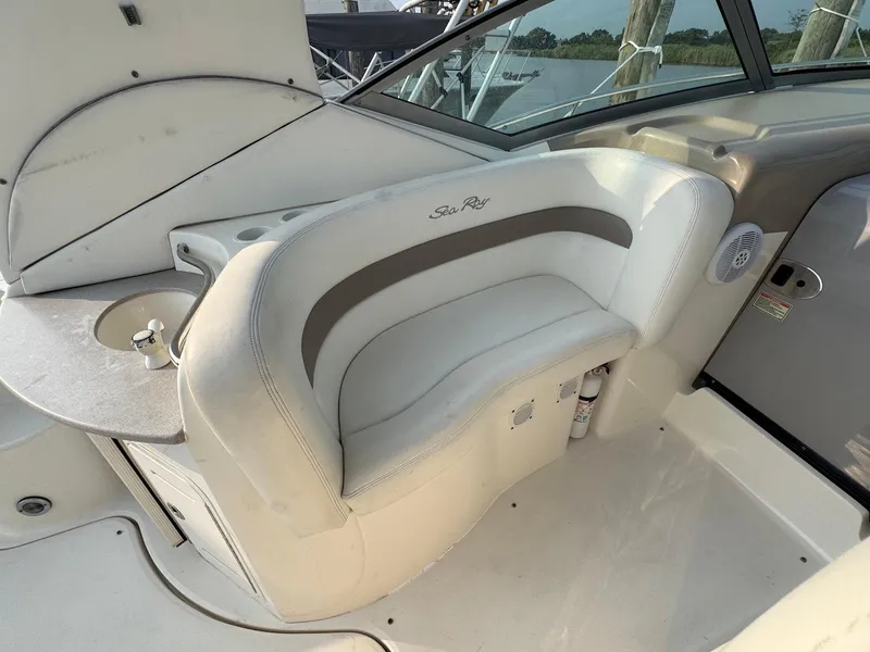 Slide: The Image of 2003 Sea Ray 320 Sundancer boat interior with white seating and small sink. - 9