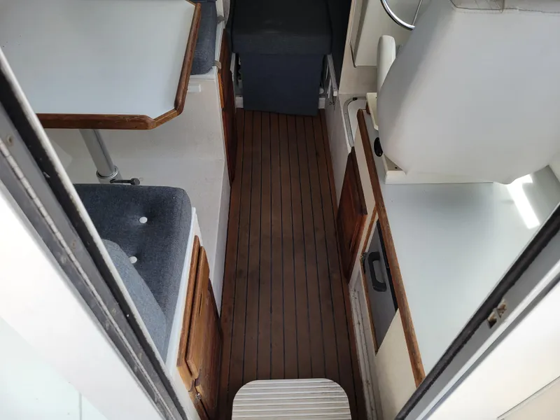 Slide: The Image of Interior of 1999 SeaSport 2400 XL Limited boat with wood flooring and seating area. - 12
