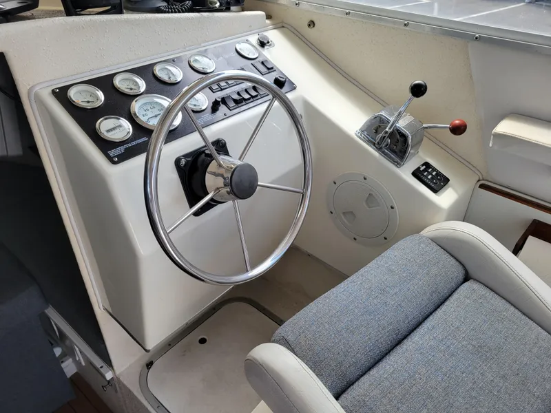 Slide: The Image of 1999 SeaSport 2400 XL Limited boat cockpit with steering wheel and control panel. - 14