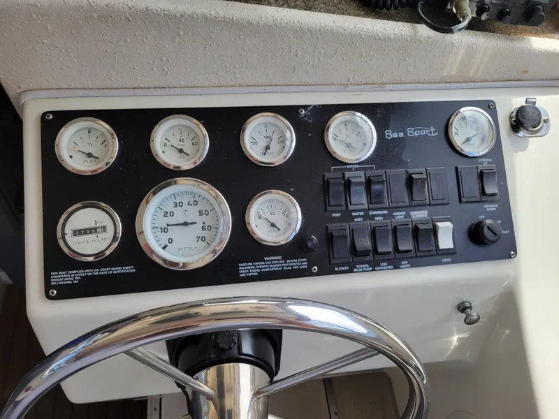 Slide: The Image of Control panel of a 1999 SeaSport 2400 XL Limited boat with gauges and switches. - 24
