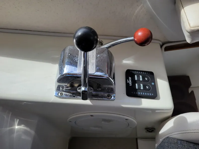 Slide: The Image of 1999 SeaSport 2400 XL Limited engine control lever and Lenco trim tab switch. - 25