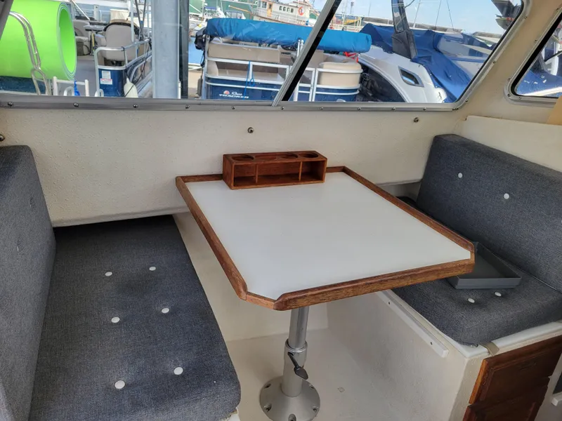 Slide: The Image of Interior of 1999 SeaSport 2400 XL Limited boat with table and seating. - 26