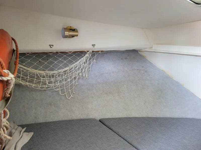 Slide: The Image of Interior of 1999 SeaSport 2400 XL Limited boat with netting and light fixture. - 28