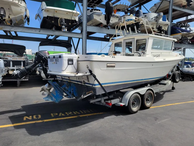 Slide: The Image of 1999 SeaSport 2400 XL Limited boat on trailer in marina storage area. - 3