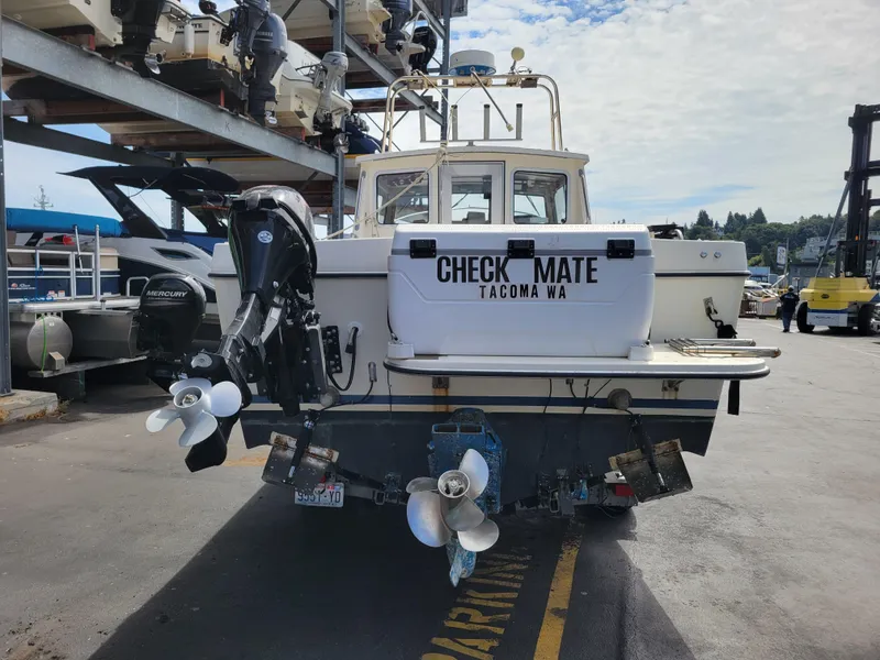 Slide: The Image of 1999 SeaSport 2400 XL Limited boat at dock, featuring dual outboard motors. - 4
