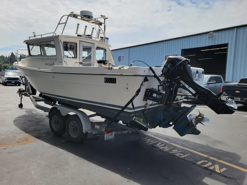 Slide: The Image of 1999 SeaSport 2400 XL Limited boat on trailer in parking lot. - 5