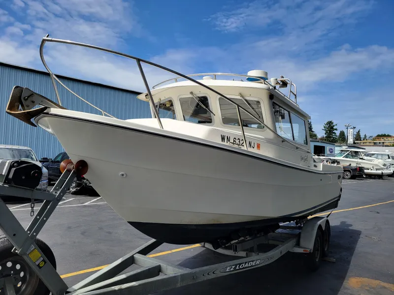 Slide: The Image of 1999 SeaSport 2400 XL Limited boat on trailer, parked outdoors under blue sky. - 7