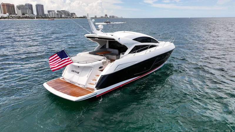 Slide: The Image of 2017 Sunseeker Predator 57 yacht cruising on open water with city skyline in background. - 29