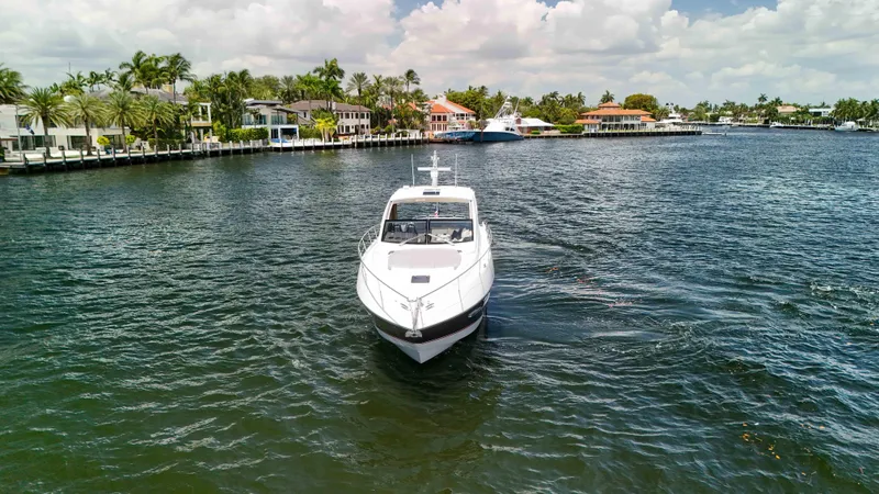 Slide: The Image of 2017 Sunseeker Predator 57 yacht cruising in a scenic waterfront area. - 3