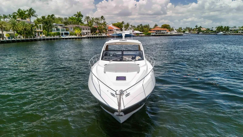 Slide: The Image of 2017 Sunseeker Predator 57 yacht on a scenic waterfront with palm trees. - 4