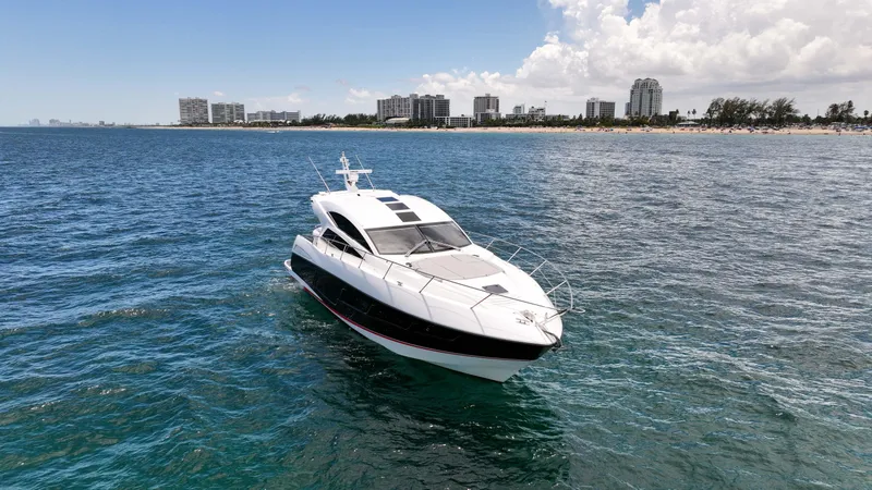 Slide: The Image of 2017 Sunseeker Predator 57 yacht cruising near a coastal city skyline. - 40