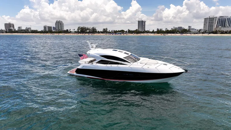Slide: The Image of 2017 Sunseeker Predator 57 yacht cruising near a city shoreline under a cloudy sky. - 41