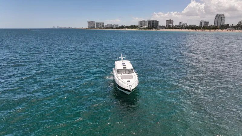 Slide: The Image of Sunseeker Predator 57 yacht cruising near a coastal city skyline, 2017 model. - 43