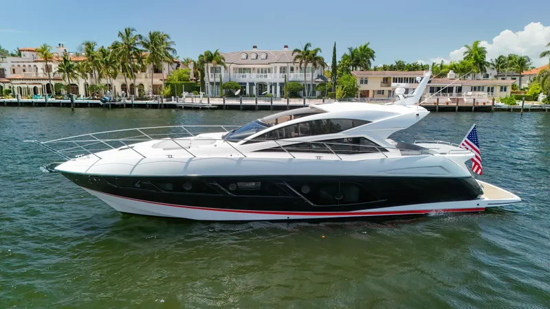 Slide: The Image of 2017 Sunseeker Predator 57 yacht cruising near luxury waterfront homes. - 6