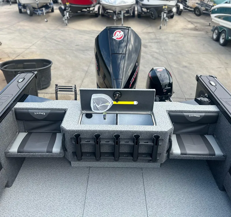Slide: The Image of 2026 Lund 2075 Fisherman boat interior with rod holders and outboard motor. - 17