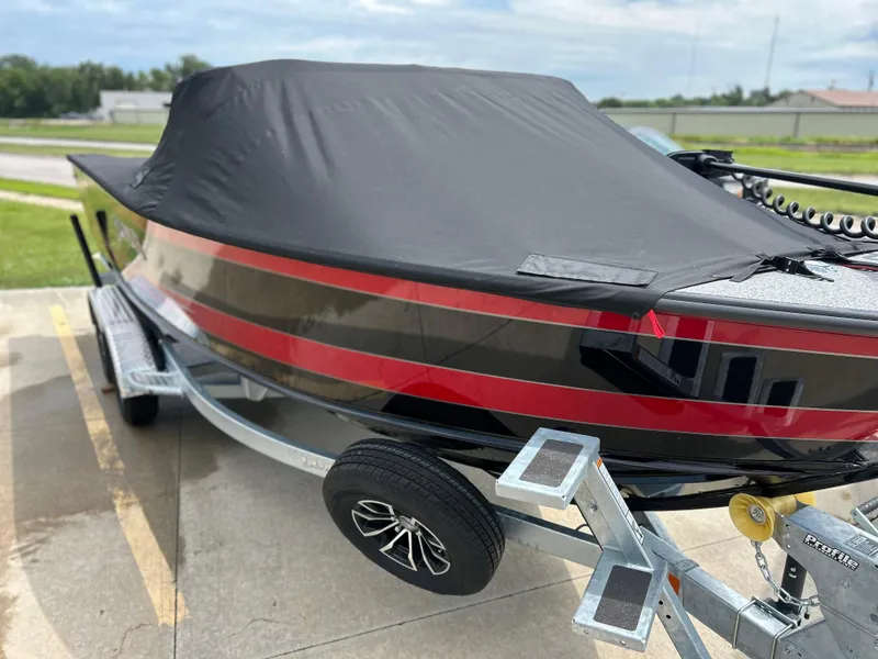 Slide: The Image of 2026 Lund 2075 Fisherman boat with cover on trailer, featuring sleek red and black design. - 6