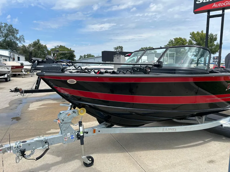 Slide: The Image of 2026 Lund 2075 Fisherman boat on trailer, black and red design, outdoor dealership display. - 9