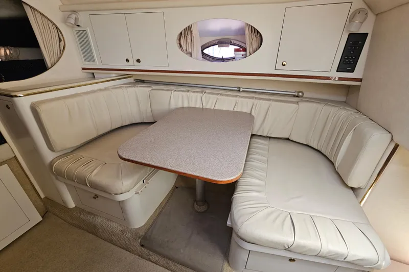 Slide: The Image of 2001 Sea Ray 290 Amberjack cabin interior with cushioned seating and table. - 24