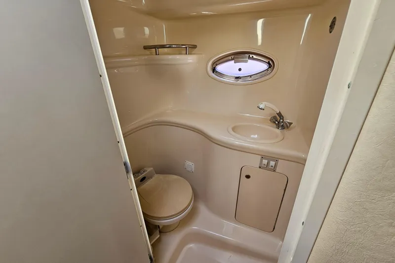 Slide: The Image of 2001 Sea Ray 290 Amberjack bathroom with sink, toilet, and porthole window. - 25
