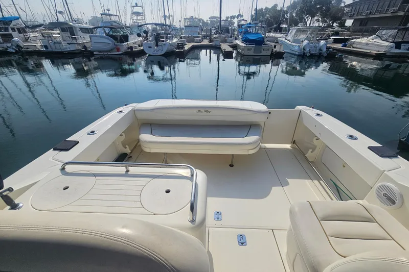 Slide: The Image of 2001 Sea Ray 290 Amberjack boat interior at marina, featuring spacious seating and calm waters. - 7