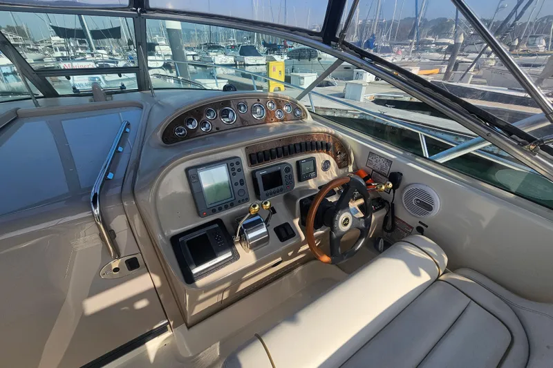 Slide: The Image of 2001 Sea Ray 290 Amberjack helm with navigation instruments and steering wheel at marina. - 9