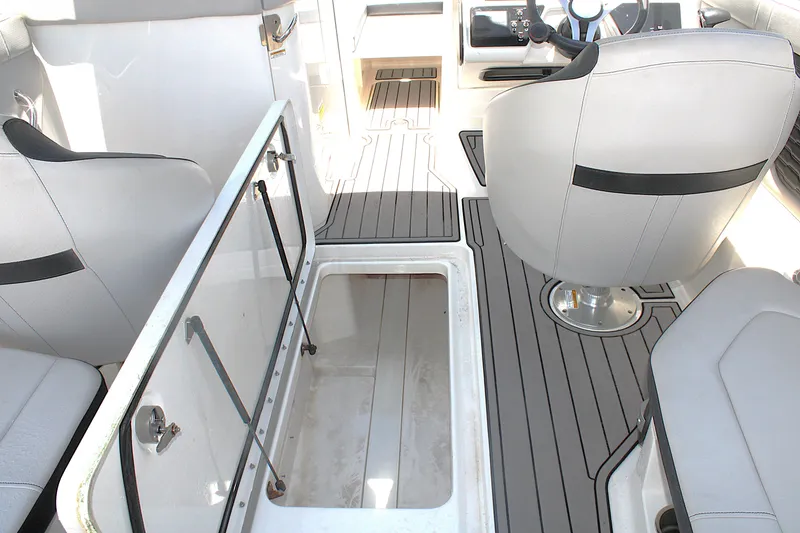 Slide: The Image of 2023 Sea Ray SPX 230 Outboard interior with open storage compartment and seating. - 13