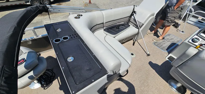 Slide: The Image of 2022 Ranger 223FC boat interior with seating, table, and fishing rod holder. - 13
