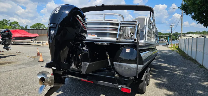 Slide: The Image of 2022 Ranger 223FC pontoon boat with Mercury outboard motor, parked outdoors on a sunny day. - 5